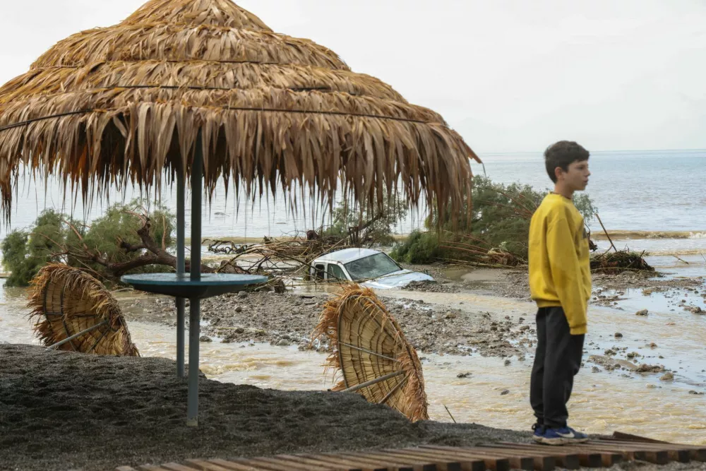 A boy stands by a damaged beach bar, after heavy rain continues to affect parts of Crete, prompting authorities to maintain severe weather warnings, in Therma near Ierapetra, Crete island, Greece, October 3, 2026. REUTERS/Stefanos Rapanis