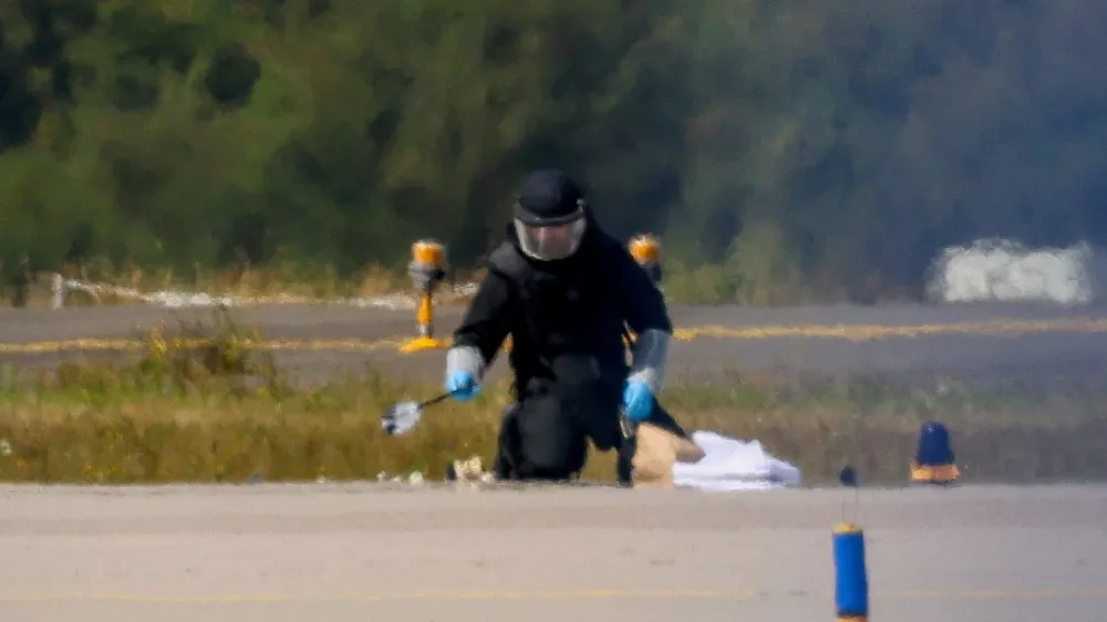 FILE PHOTO: A police officer in protective clothing works at Leipzig/Halle Airport in Schkeuditz, Germany, August 5, 2026, after the police said explosives experts examined a drone near a runway, and after a DHL cargo aircraft hit an unknown object as it was climbing away from the airport overnight, prompting an unscheduled landing in Hanover, according to a source familiar with the incident. REUTERS/Axel Schmidt/File Photo