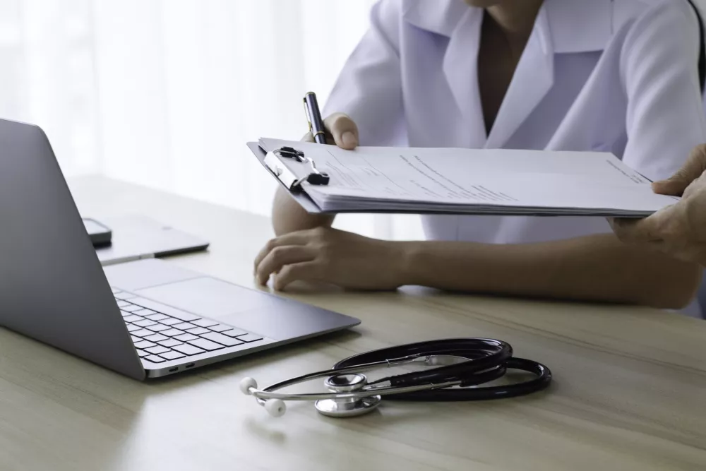 Doctor giving medical health report prescription and work on laptop computer at office desk in clinic or hospital. / Foto: Everyday Better To Do Everything