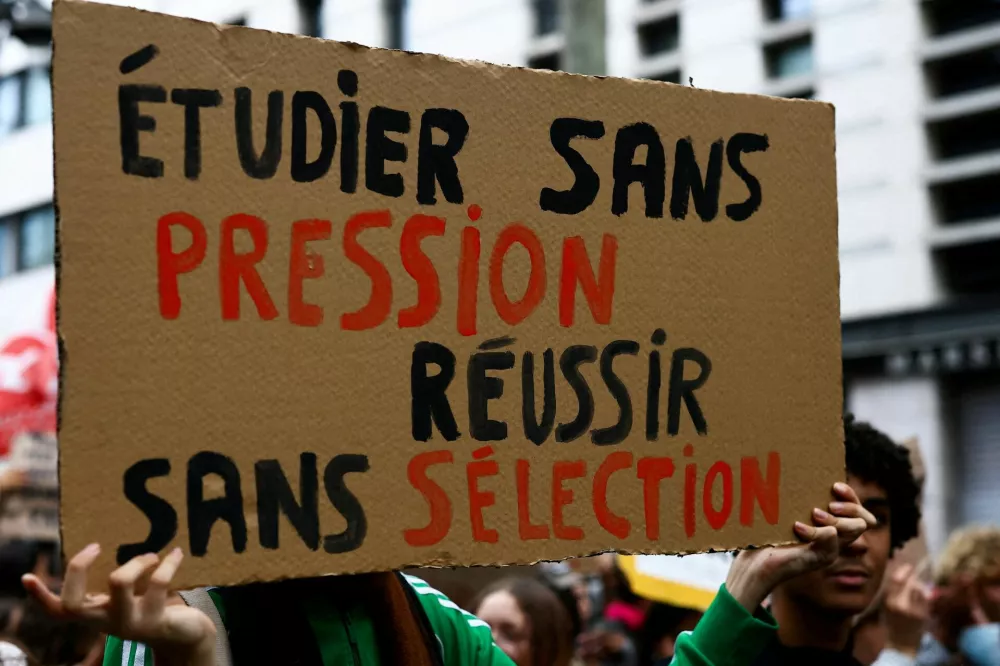 Protesters march during a demonstration by French high school students in Marseille, as part of a nationwide day of protests and blockades, expressing anger over overcrowded classrooms, teacher shortages and dilapidated school buildings, which students blame on years of underinvestment, in Marseille, France, October 8, 2026. A placard reads: "Learn without pressure, succeed without selection". REUTERS/Manon Cruz REFILE - FIXING TYPO IN "PLACARD".