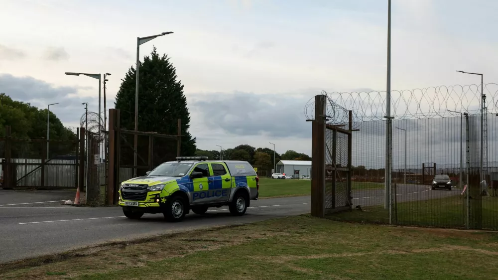A police car leaves RAF Molesworth, after two Latvian nationals were arrested on suspicion of entering a prohibited place for a purpose prejudicial to the UK, police said in a statement, in Cambridgeshire, Britain, October 8, 2026. REUTERS/Chris Radburn   TPX IMAGES OF THE DAY