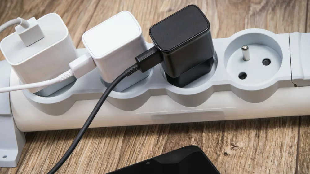 Smartphone, mobile phone and chargers connected to electrical power strip. Various devices charging concept. Smartphone and chargers connected to electrical power strip. Various devices charging concept,Image: 1129613115, License: Royalty-free, Restrictions:, Model Release: no 