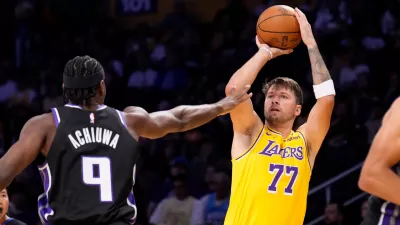 Los Angeles Lakers forward/guard Luka Dončić, right, shoots as Sacramento Kings forward Precious Achiuwa defends during the first half of a preseason NBA basketball game Thursday, Oct 8, 2026, in Los Angeles. (AP Photo/Mark J. Terrill)