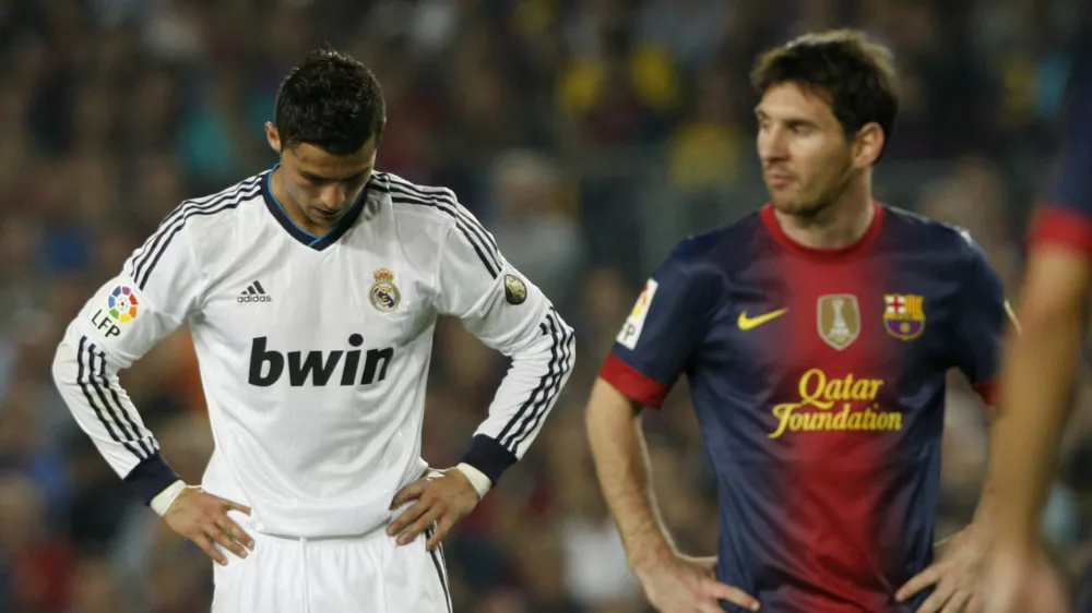 Barcelona's Lionel Messi (R) walks past Real Madrid's Cristiano Ronaldo during their Spanish first division soccer match at Nou Camp stadium in Barcelona, October 7, 2012.  REUTERS/Albert Gea (SPAIN - Tags: SPORT SOCCER)