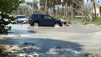 A man tries to push a car as waves wash over the road ahead of the arrival of Hurricane Isaias, in Englewood, Florida, US, October 9, 2026. Englewood Area Fire Control District via Facebook/Handout via REUTERS  THIS IMAGE HAS BEEN SUPPLIED BY A THIRD PARTY. NO RESALES. NO ARCHIVES. MANDATORY CREDIT. Verification lines: Buildings, electricity poles, road signs, road layout and trees matched file and satellite images in the area. Date verified by government reports of Manasota Key Road in Englewood, Florida was closed due to waves washing over road. The US National Hurricane Center said Hurricane Isaias made landfall in western Florida panhandle, warning of danger from storm surges and floods.
