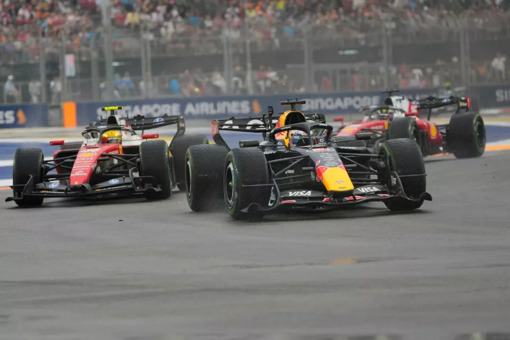 Red Bull driver Max Verstappen, center, of the Netherlands steers his car ahead of Ferrari driver Lewis Hamilton, left, of Britain and Ferrari driver Charles Leclerc of Monaco during the sprint race ahead of the Singapore Formula One Grand Prix in Singapore, Saturday, Oct. 10, 2026. (AP Photo/Vincent Thian)