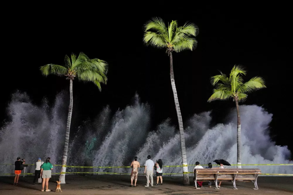 People watch waves crash against the waterfront promenade as Hurricane Simon approaches Mexico's Pacific coast in Puerto Vallarta, Mexico, October 11, 2026. REUTERS/Christian Ruano