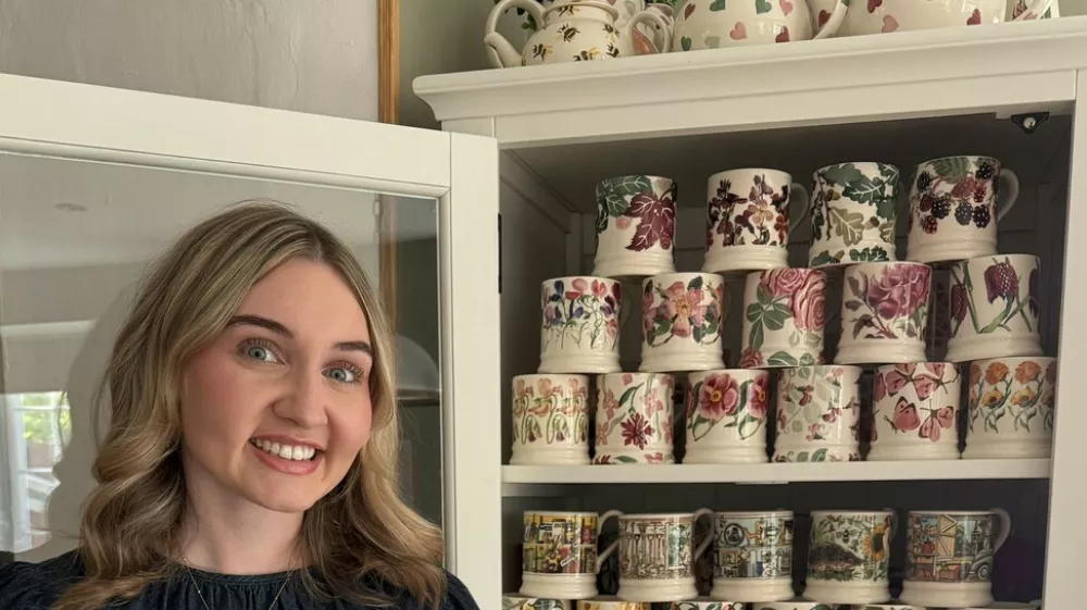 Story from Jam Press (Mug Collection)Pictured: Amy showing her mug collection.'I have spent Ł2,500 on MUGS in search of the perfect cuppa with over 250 options in a dedicated cupboard &ndash; but I always pull out THIS one for builders'A woman obsessed with finding the perfect cuppa has spent over Ł2,500 on mugs &ndash; for which she has a dedicated cupboard that leaves people shocked.Amy Sinfield has gone viral after sharing the extent of her passion, which has seen her purchase 100 new mugs in the past year &ndash; that's more than eight every month.In total, the 26-year-old has 256 mugs worth thousands, including a special Emma Bridgewater collection that retails at upwards of Ł20 a pop and a Sports Direct mug specifically for "workmen".Viewers online were left stunned when earlier this month, Amy revealed where she keeps her many mugs, in a clip that has over 800,000 views."A lot of my wage goes towards growing the collection," Amy, a project officer from Bedford, told creatorzine.com."Buying a new mug feels almost like a therapy session to me &ndash; a cuppa always tastes better in a new mug."I actually had to pause buying mugs for a while at my previous house because I completely ran out of cupboard space &ndash; I was at about 100 by that point."[Now], my dedicated mug cabinet is perfect because it's deep enough to stack them all the way back."I also use two kitchen cupboards above my coffee machine for seasonal pieces and daily favourites like my Le Creuset, Eleanor Bowmer, and Cornishware items."I live with my husband, Jack, and he definitely lives by the saying, 'Happy wife, happy life!'"Some people think I'm exaggerating, so when they see the collection in person, it's always a shock."It's hard to envision 250 mugs, so to see the collection in person, they realise it's huge."It takes them a few minutes to pick a mug, for sure."I [might] offer a Le Creuset, as those are crowd-pleasers."[But] whenever we have workmen over, I pull out a giant Sports Direct mug I keep hidden at the back of the cupboard specifically for them!"As for how she chooses her daily mug from the sprawling collection?Amy said: "The mug I pick every day always depends on my mood and, nine times out of 10, my outfit."I love coordinating what I wear with my mug &ndash; little details like that really help me romanticise daily life."I also have plenty of seasonal pieces, so during autumn, I'll strictly use my autumnal mugs, followed by Christmas, spring, and so on."Amy's collection started seven years ago, and was partly inspired by her mum, who similarly has a huge collection, spanning just under 300 mugs.She said: "Eight years ago, we visited the Emma Bridgewater shop at Bicester Village where I bought my first-ever piece, and that was just the start."While I mainly collected that brand at first, I've since discovered others like Le Creuset, Sophie Allport, Gisela Graham, Eleanor Bowmer, and Cornishware, which I absolutely adore."While most 21-year-olds want a big night out for their birthday, I spent my 21st at the Emma Bridgewater factory!"As for the future, Amy doesn't have a mug goal in mind, but she has no plans of slowing down.She added: "I'll definitely keep adding to it &ndash; it's hard to stop when my favourite brands keep releasing gorgeous new designs."A major life goal of mine would be to collaborate with a brand to design my own collection; that would be the absolute dream."ENDSEDITOR'S NOTE: Exclusive Licence: An exclusive licence has been obtained directly from the verified copyright holder. Jam Press holds exclusive distribution rights for the agreed content within the terms of the contributor agreement.,Image: 1138001936, License: Rights-managed, Restrictions: EDITOR'S NOTE: Exclusive Licence: An exclusive licence has been obtained directly from the verified copyright holder. Jam Press holds exclusive distribution rights for the agreed content within the terms of the contributor agreement., Model Release: no 