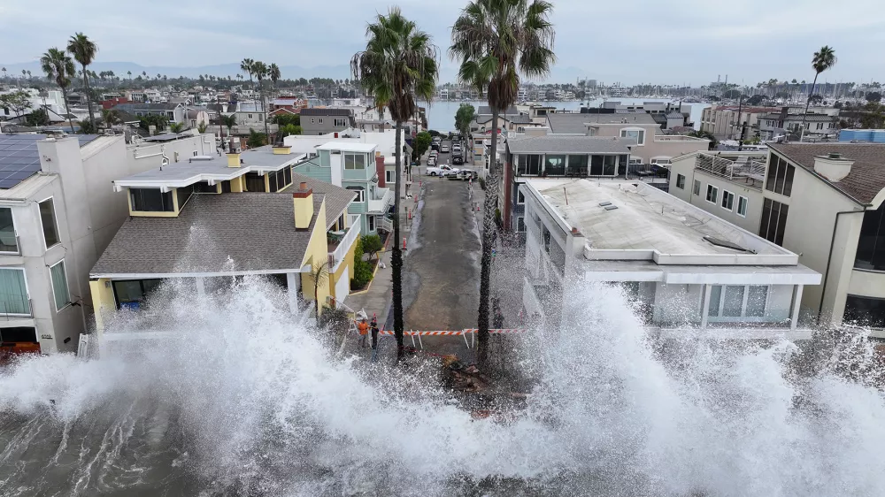 Waves hit a walkway in front of homes in Long Beach, Calif., Saturday, Oct. 10, 2026, as Tropical Storm Rachel approaches. (AP Photo/William Liang)