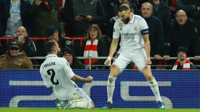 Soccer Football - Champions League - Round of 16 First Leg - Liverpool v Real Madrid - Anfield, Liverpool, Britain - February 21, 2023 Real Madrid's Karim Benzema celebrates scoring their fourth goal with Dani Carvajal REUTERS/Phil Noble