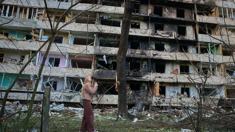 A young woman reacts as she looks at her damaged home after Russia's night missile attack in Kyiv, Ukraine, Wednesday, Oct. 14, 2026. (AP Photo/Efrem Lukatsky)
