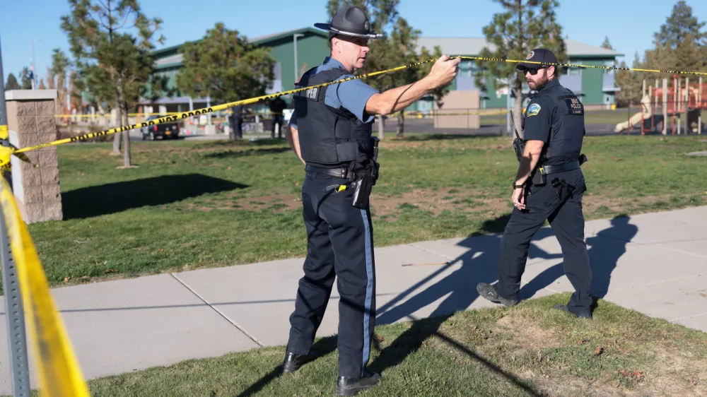An emergency worker holds up police tape at the scene of a shooting at Silver Rail Elementary School in Bend, Oregon, US, October 15, 2026. REUTERS/Rob Kerr