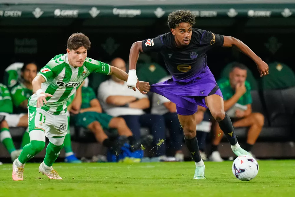 Betis' Fran Garcia, left, challenges for the ball with Barcelona's Lamine Yamal during the Spanish La Liga soccer match between Real Betis and Barcelona in Seville, Spain, Saturday, Oct. 17, 2026. (AP Photo/Jose Breton)