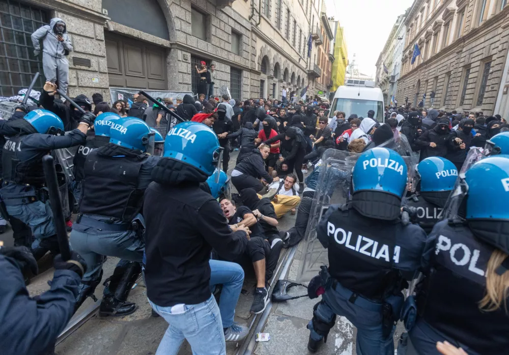 Demonstrators and riot police clash during a protest against the high cost of living, in Milan, Italy, Saturday Oct. 17, 2026. (Stefano Porta/LaPresse via AP)
