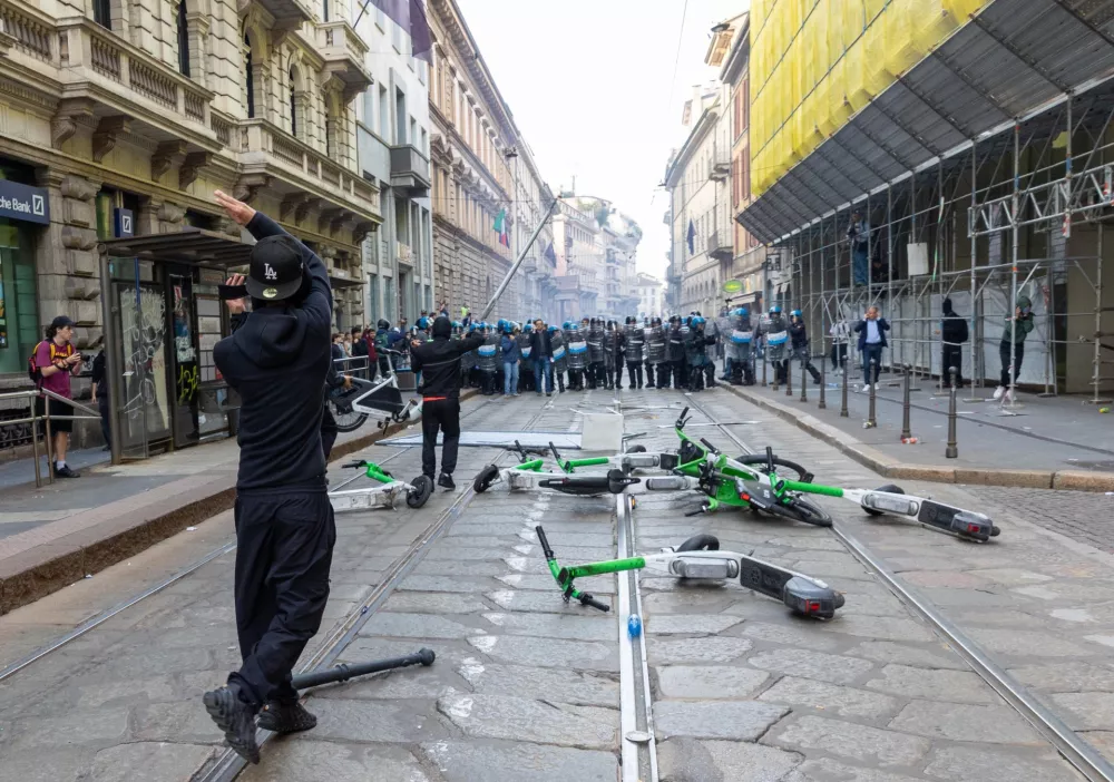 Demonstrators throw objects towards the riot police after clashes occurred during a protest against the high cost of living, in Milan, Italy, Saturday Oct. 17, 2026. (Stefano Porta/LaPresse via AP)