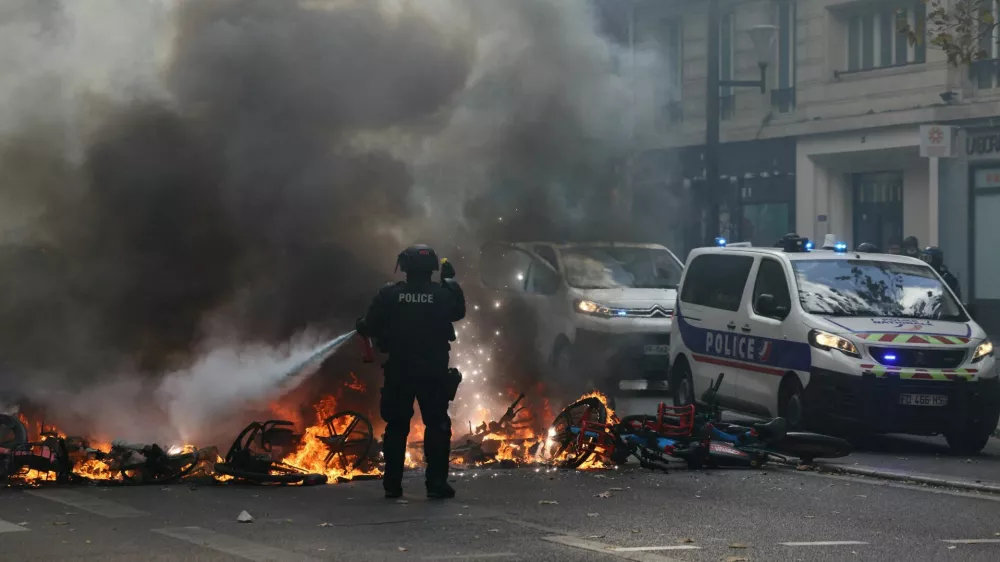 FILE PHOTO: A French police officer extinguish burning bicycles during a demonstration against the cost of living and rising fuel prices in Paris as part of nationwide protests called by the "Yellow Vests" movement, joined by French high school and university students, teachers and parents demanding better school conditions and government action, as well as labour unions, workers, farmers and retirees, France, October 17, 2026.  REUTERS/Jack Taylor/File Photo