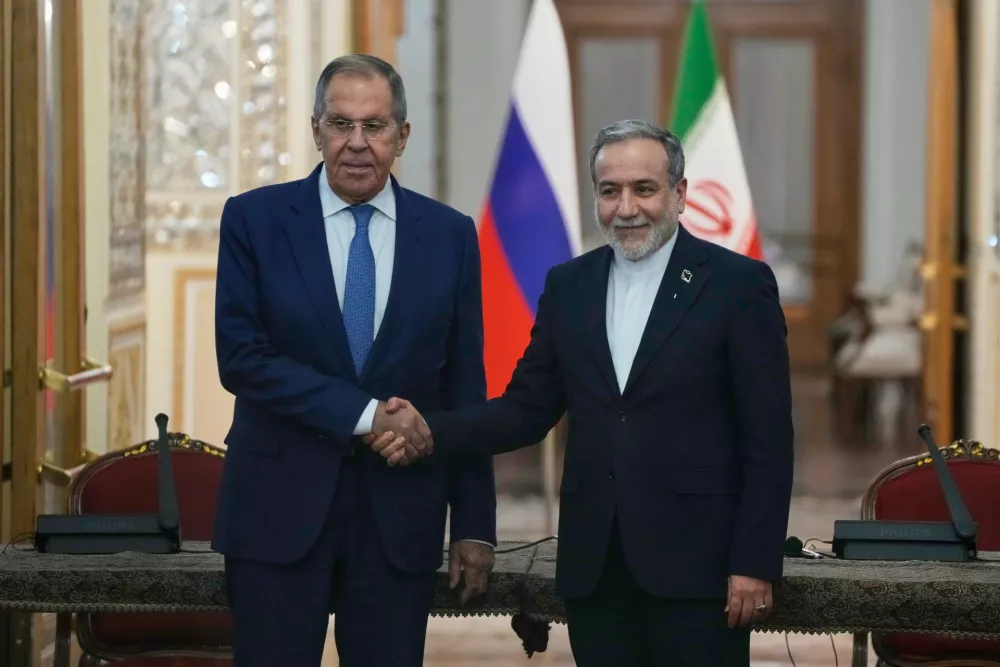 Iranian Foreign Minister Abbas Araghchi, right, and Russian Foreign Minister Sergey Lavrov shake hands after their meeting at Iran's Foreign Ministry in Tehran, Iran, Monday, Oct. 19, 2026. (AP Photo/Vahid Salemi)