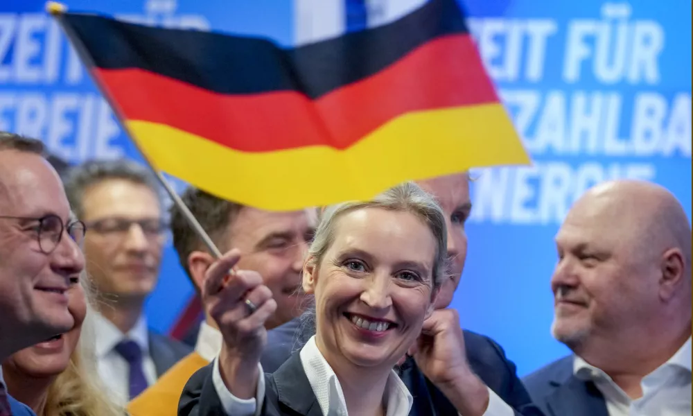 Leader of far right AfD Alice Weidel waves a German flag at the AfD party headquarters in Berlin, Germany, Sunday, Feb. 23, 2025, after the German national election. (AP Photo/Michael Probst)