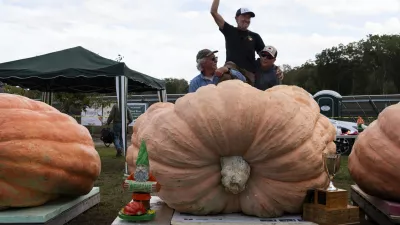 Richmond, RI - October 8: Steve Sperry, center, is lifted in the air by Joe Jutras, left, and Ron Wallace, right, after Sperry's pumpkin set a personal best weight of 2,465.5 lbs at the weigh-off at Pasquale Farm. (Photo by Tanner Pearson/The Boston Globe via Getty Images)