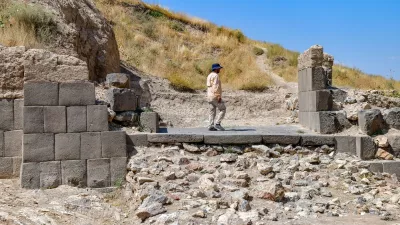 An archaeologist walk walks through the ruins of the fortress of Ayanis near Van, in eastern Turkey, on August 4, 2026. Although it emerged later than the great Mesopotamian kingdoms of Assyria, Sumer, and Babylon, Urartu succeeded in uniting the tribal communities of the Autoru Mountains into a centralized state, building fortresses, provincial capitals, irrigation networks, and vast storage facilities to support an agricultural economy.,Image: 1121981093, License: Rights-managed, Restrictions: Graphic ContentTO GO WITH AFP STORY BY ANNE CHAON, Model Release: no 