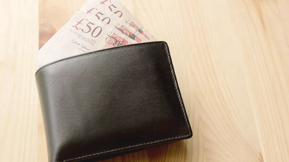 High Angle View Of Modern Black leather Men's Wallet With Pound Cash On The Old Rough Wood Textured Background With Copy Space / Foto: Photobuay
