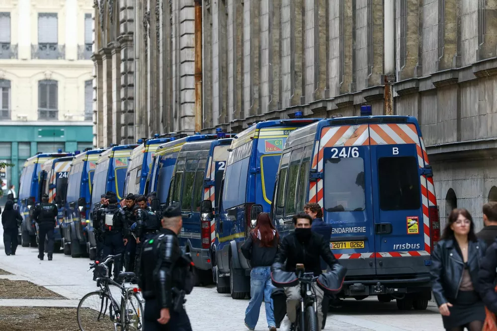 Police officers stand next to a line of police vehicles, as demonstrations called by the "Yellow Vests" movement, joined by French high school and university students, against the cost of living and rising fuel prices have been banned by local authorities, in Lyon, France, October 24, 2026. REUTERS/Lisi Niesner