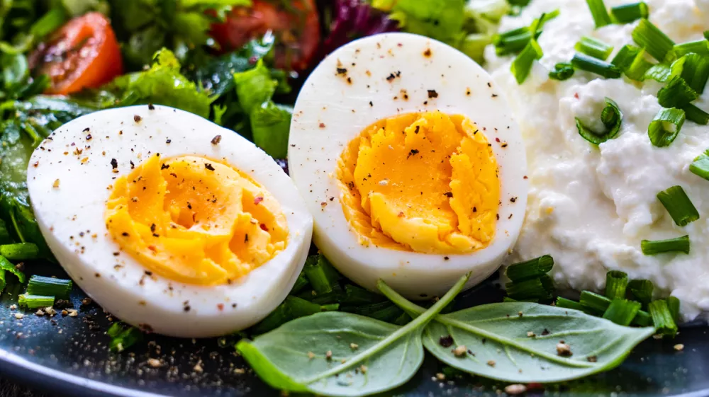 Breakfast - hard-boiled egg, homemade bread, cottage cheese and vegetables on wooden table / Foto: Gbh007 Getty Images/istockphoto