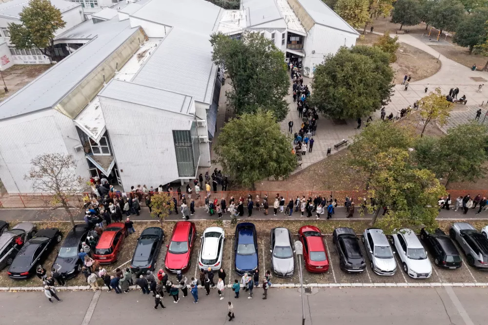 People wait outside a polling station during the parliamentary election in Novi Sad, Serbia, Sunday, Oct. 25, 2026. (AP Photo/Armin Durgut)