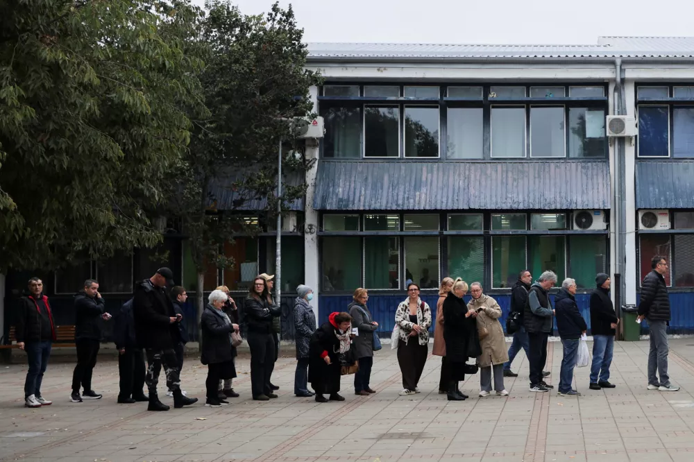 People queue outside a polling station to cast their votes during the parliamentary election in Novi Sad, Serbia, October 25, 2026. REUTERS/Uros Arsic