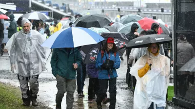 Spectators attempt to shelter from the rain prior to the MotoGP race being called off due to bad weather for the Australian Motorcycle Grand Prix at the Phillip Island near Melbourne, Australia, Sunday, Oct. 25, 2026. (Joel Carrett/AAP Image via AP)