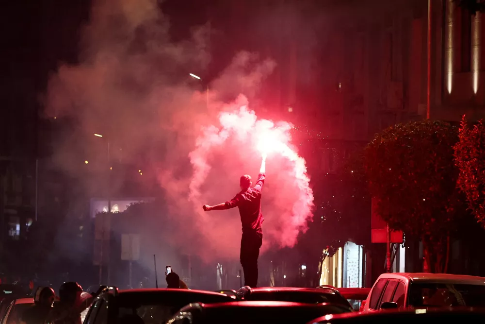 A person lights a flare as supporters of the electoral list "Student List - Students Win" celebrate following the first results of the parliamentary election in Belgrade, Serbia, October 25, 2026. REUTERS/Zorana Jevtic