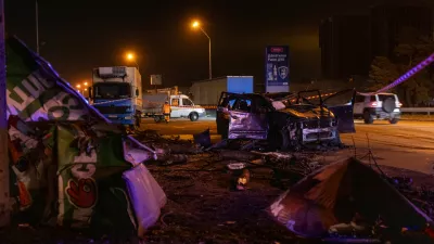 Emergency workers clear debris and damaged road infrastructure near a destroyed car following a Russian overnight strike in Kyiv, Ukraine, Tuesday, Oct. 27, 2026. (AP Photo/Dan Bashakov)