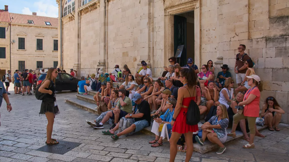 Dubrovnik. Croatia - November 01, 2025: Visitors gather on the stone steps of the famous baroque stairway in Stari Grad on a sunny day.