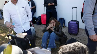 A survivor reacts while waiting to board a bus outside the municipal center where they have been taken, following the collision of two high-speed trains between the towns of Mora and Orgaz, in Urda, Spain, October 28, 2026. REUTERS/Susana Vera