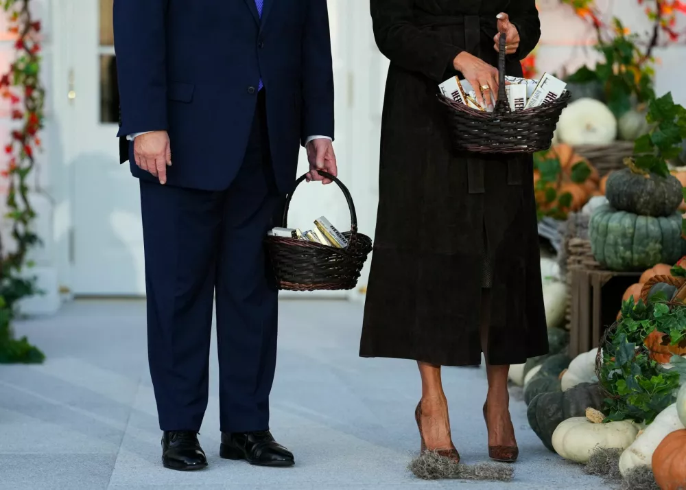 US President Donald Trump and first lady Melania Trump carry candies as they host a Halloween event at the White House in Washington, DC, US, October 29, 2026. REUTERS/Eric Lee