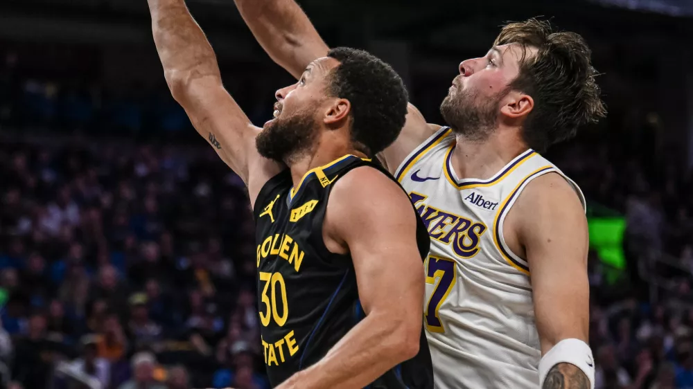 Los Angeles Lakers guard Luka Doncic (77) blocks Golden State Warriors guard Stephen Curry (30) during the second half of an NBA Cup basketball game, Saturday, Oct. 30, 2026, in San Francisco. (AP Photo/Justine Willard)
