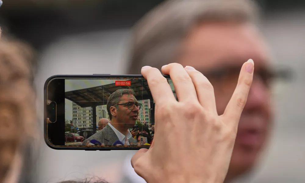 A person records video of Aleksandar Vucic, leader of the right-wing Serbian Progressive Party (SNS), speaking to media after voting in a parliamentary election in Belgrade, Serbia, Sunday, Oct. 25, 2026. (AP Photo/Darko Vojinovic)