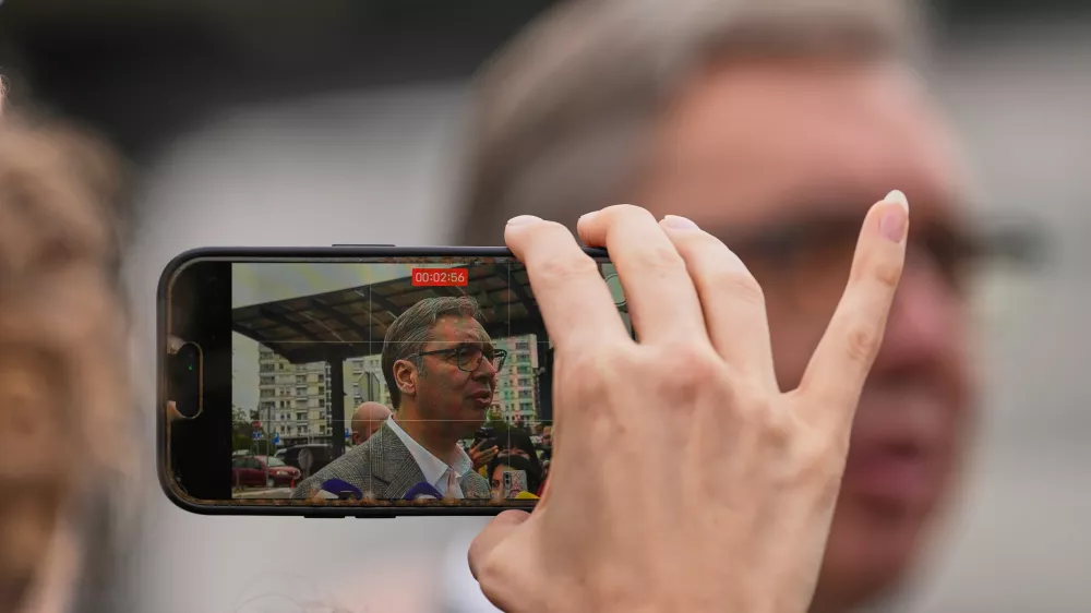 A person records video of Aleksandar Vucic, leader of the right-wing Serbian Progressive Party (SNS), speaking to media after voting in a parliamentary election in Belgrade, Serbia, Sunday, Oct. 25, 2026. (AP Photo/Darko Vojinovic)