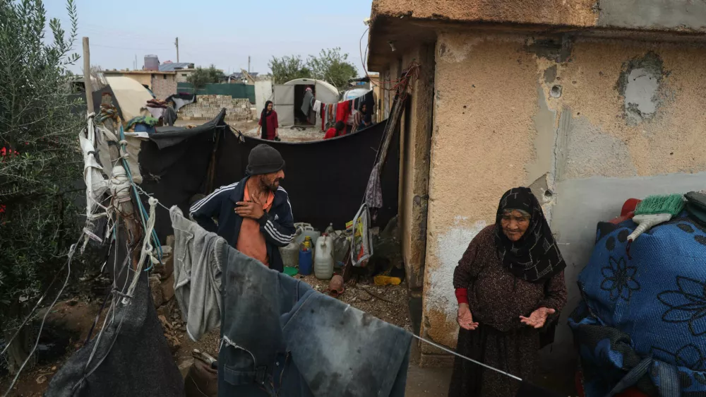 Displaced Syrians stand outside their makeshift shelters following a rainstorm at the Al-Talae displacement camp in Hasakah, northeastern Syria, Thursday, Oct. 29, 2026. (AP Photo/Baderkhan Ahmad)